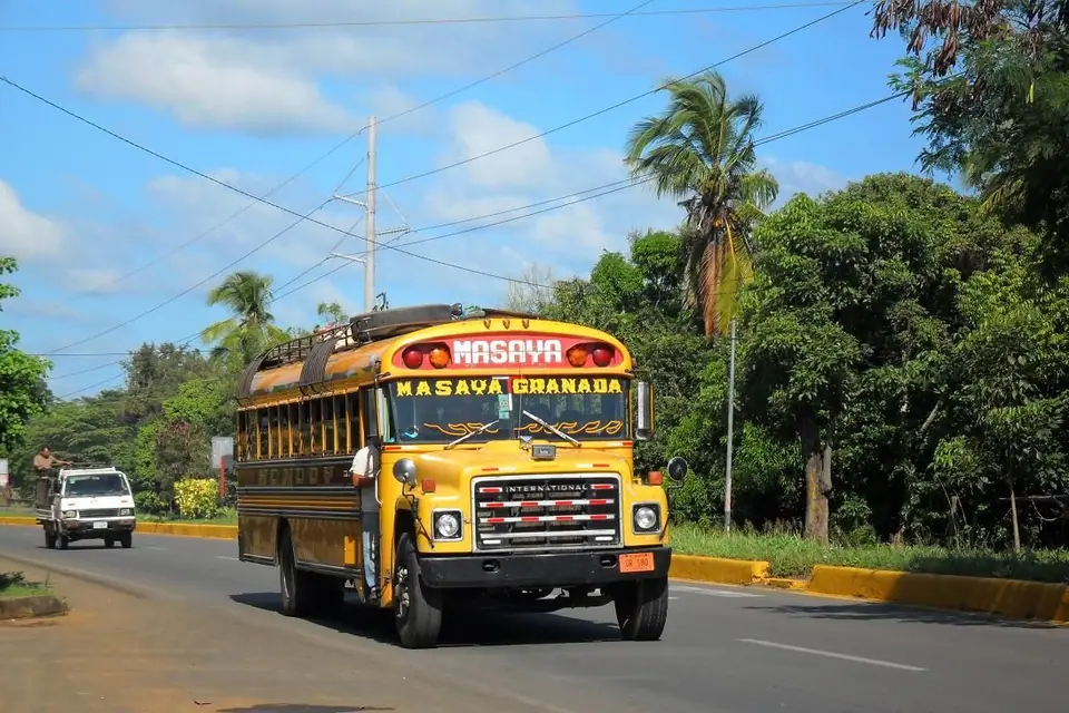 Bus amarillo con el rótulo Masaya Granada en la carretera