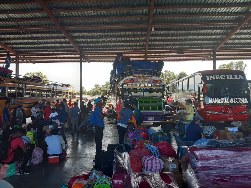 Buses y puestos de venta bajo el techo de una terminal de Managua